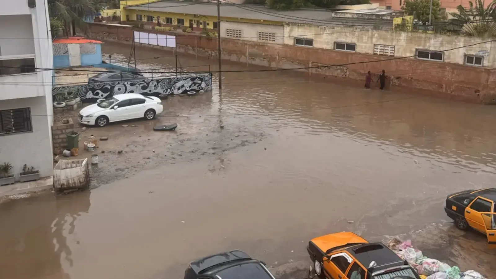 Une rue largement recouverte d’eau boueuse après une forte pluie à Dakar